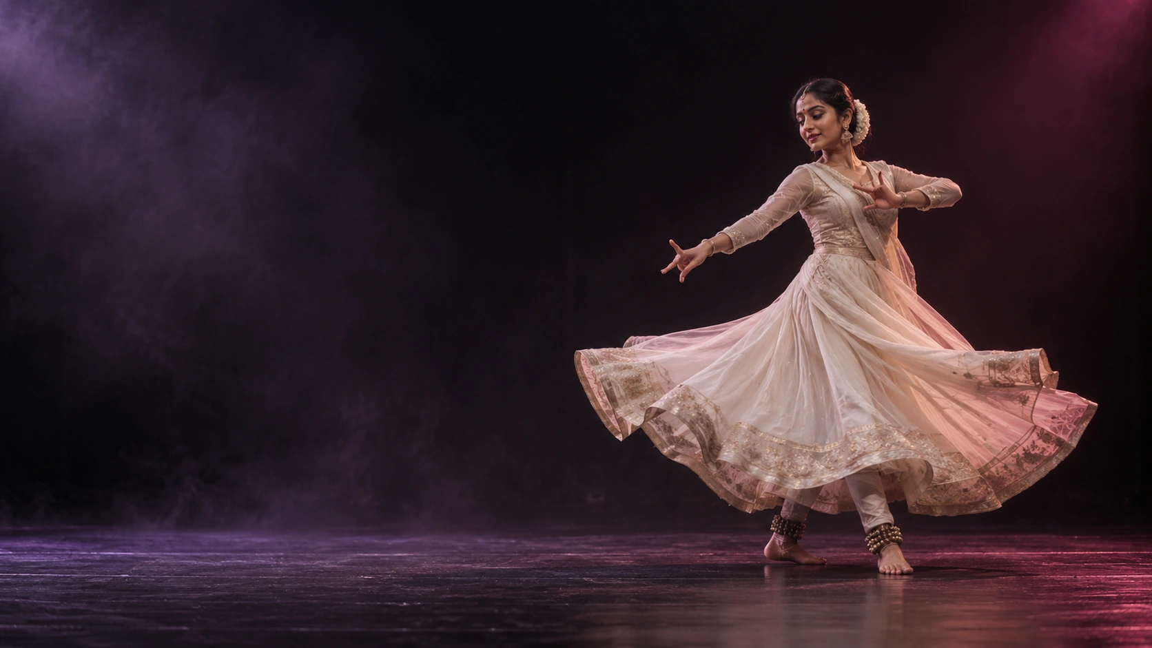 Indian dancer moving across a dark stage in TAALYARD's full-width hero